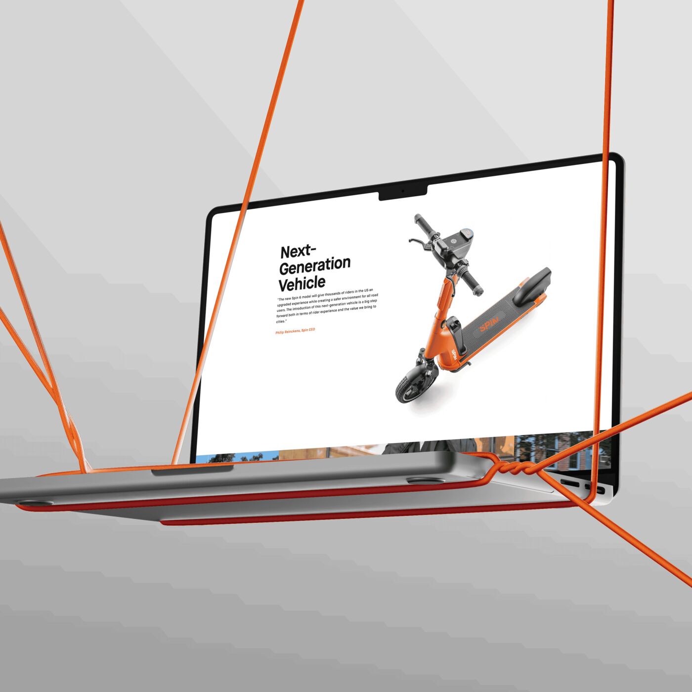 A MacBook suspended by orange cords showing the Spin next-generation vehicle page