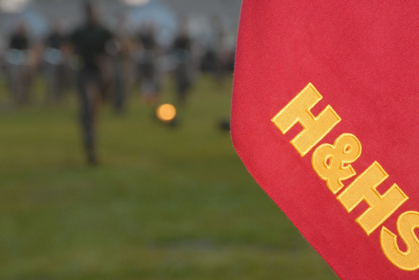 A red H&S company flag in the foreground, Marines out of focus behind it